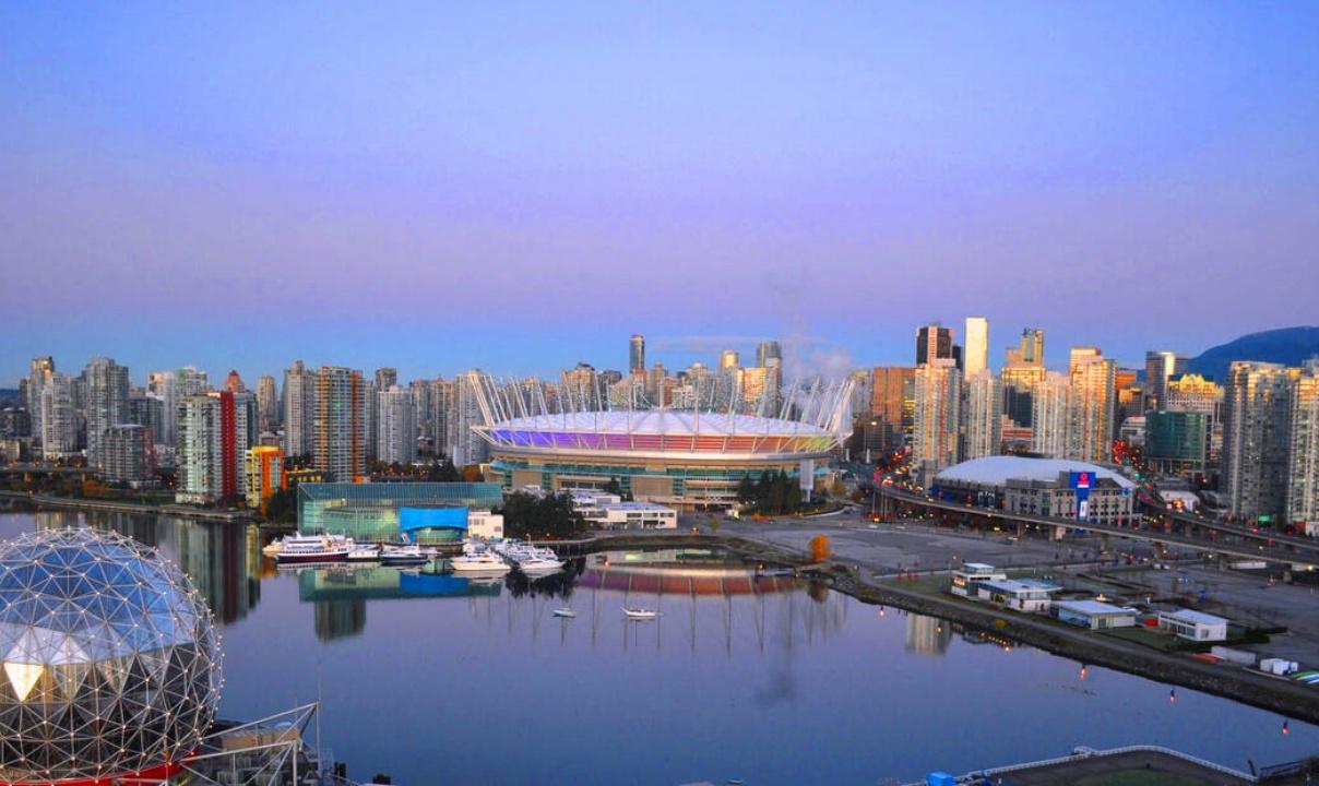 A view of False Creek, Science World, BC Place, Rogers Arena, and downtown Vancouver at twilight.
