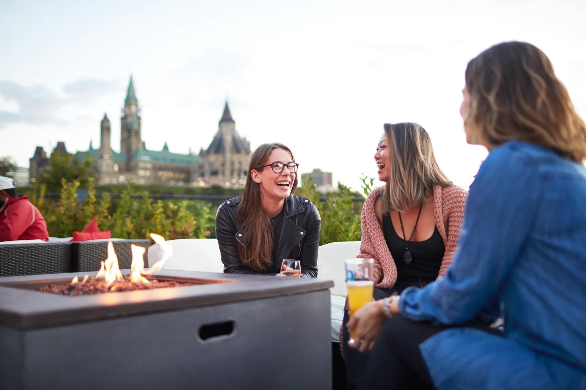 A group of women dine outside in view of the Ottawa parliament