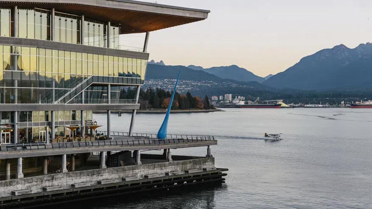 The exterior of the Vancouver Convention Centre with Vancouver Harbour and the North Shore mountains in the background.