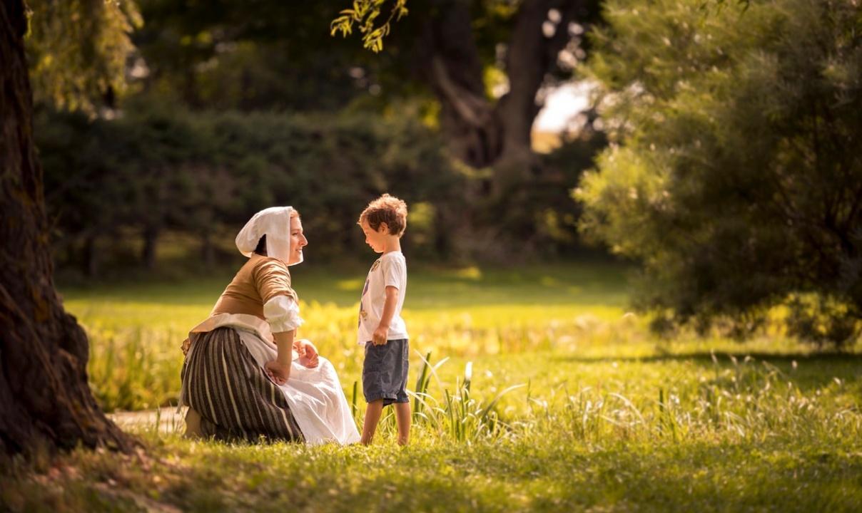 Adult and child picnicking in a park