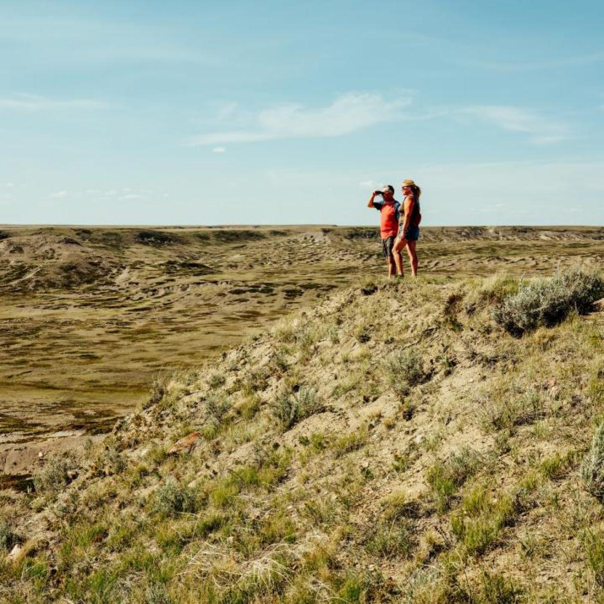 Two hikers looking out over the badlands