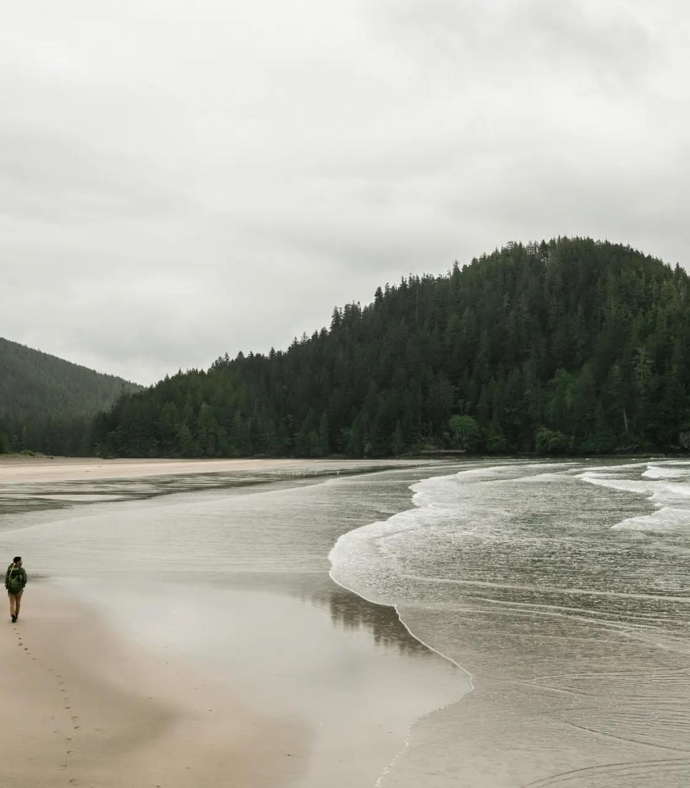 A person walks across Cape Scott beach