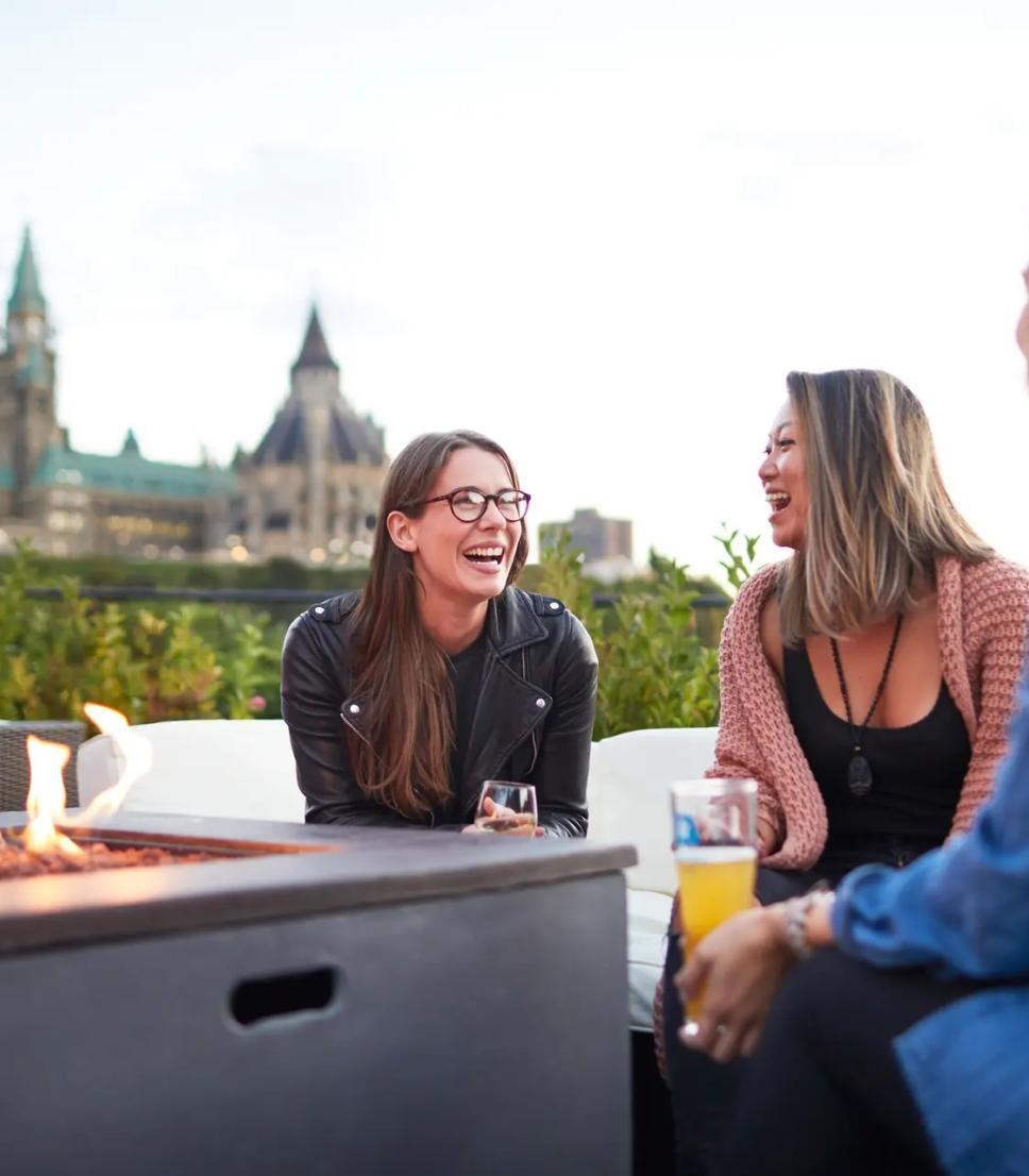 A group of women dine outside in view of the Ottawa parliament