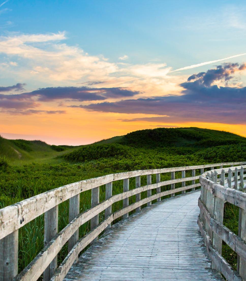 A boardwalk leading to the beach at sunset