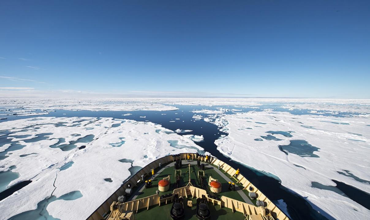 The prow of a ship moving through ice-filled water.