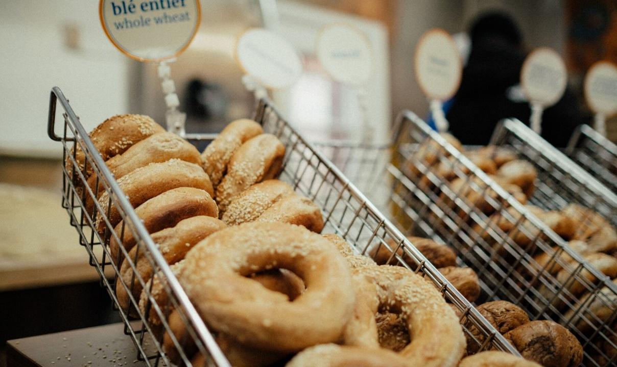 A wire basket full of sesame seed bagels.