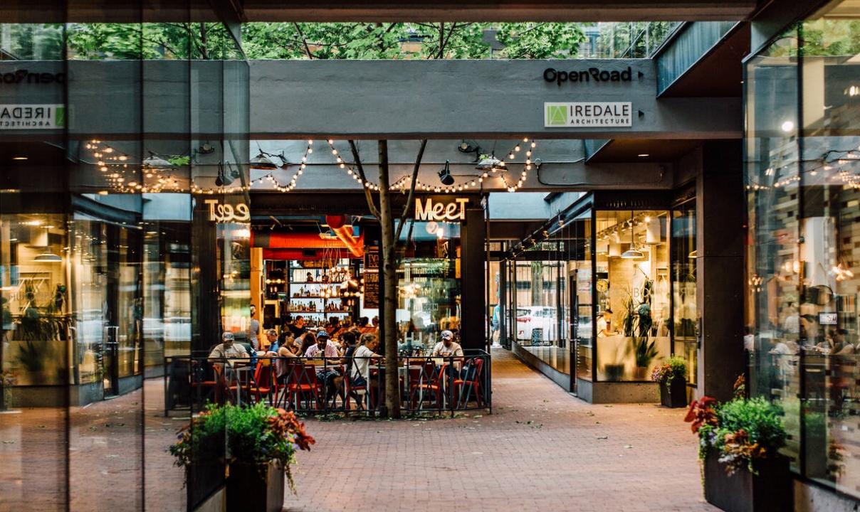 Restaurants and shops surrounding a brick courtyard in Vancouver, BC.