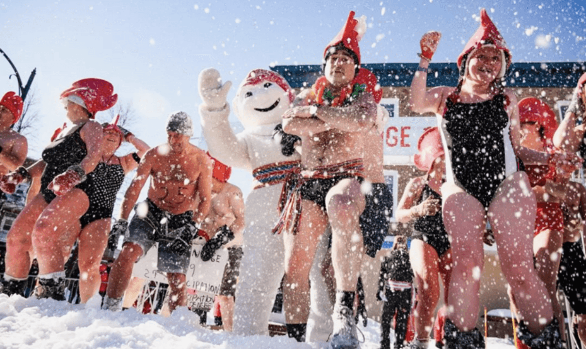 A group of people in bathing suits standing in the snow at the Quebec Winter Carnival.