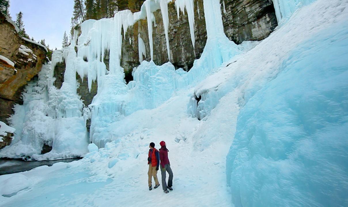 Two people exploring an ice cave.